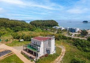 an aerial view of a house on a hill next to the ocean at Taean Gana Pension Pet friendly in Taean