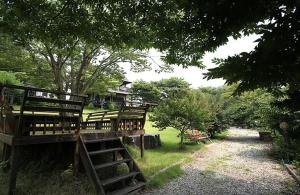 a house with wooden benches in a park at Anmyeondo Lake Park Pension in Ch'anggi-ri +14 photos