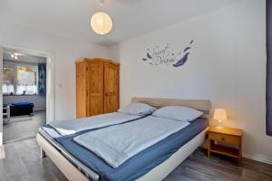 a bedroom with a bed and a wooden cabinet at tierfreundliche Ferienwohnung in Adamshoffnung +15 photos