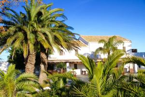 a building with palm trees in front of it at Hotel Mas Prades in Deltebre