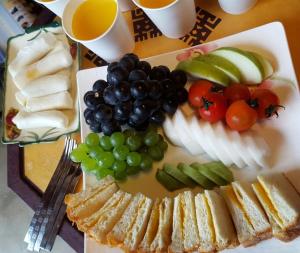 un plato de comida con uvas, pan y fruta en Jeonju Byeoljari Hanok Pension, en Jeonju