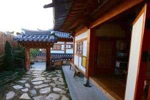 Un patio de un edificio con un banco al lado. en Jeonju Byeoljari Hanok Pension, en Jeonju 18 fotos más