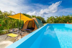 una tenda, un tavolo e delle sedie accanto a una piscina di レジーナ石垣 アクアステージ Regina Ishigaki Aqua stage a Isola di Ishigaki