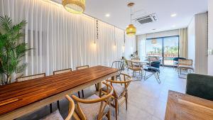 a dining room with a wooden table and chairs at Stonecove Pension in Geoje 