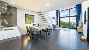 a kitchen and dining room with a table and chairs at Stonecove Pension in Geoje  +4 photos