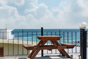 a picnic table on a balcony overlooking the ocean at Sea Bird Bed and Breakfast in Yŏngdŏk