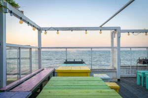 a deck with tables and benches on the beach at Daebudo Ara Pension in Ansan