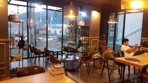 a man sitting at a table in a restaurant at Tongyeong Chorokbit Bada Pension in Tongyeong