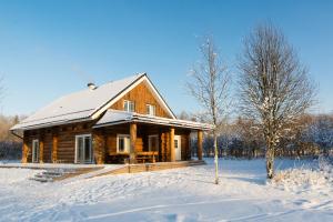 a log cabin in the snow with a tree at Humala Holiday Home in Kohila