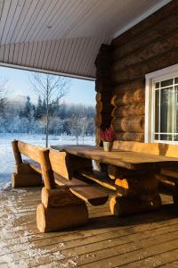 a wooden picnic table on the porch of a log cabin at Humala Holiday Home in Kohila