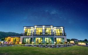 a large building with a lot of windows at night at Gyeongju Dia Pool Villa Pension in Gyeongju +4 photos