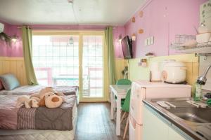 a small room with a bed with a teddy bear on it at Riverwalk Pension Chuncheon in Paegyang
