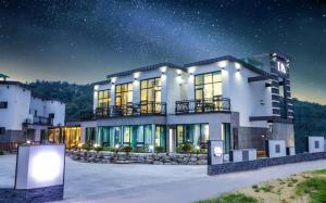 a large white house with a starry sky at Gyeongju Dia Pool Villa Pension in Gyeongju