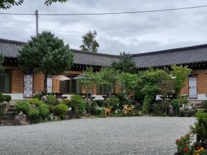 a house with a gravel driveway in front of it at Hongcheon Yongho River Pension in Hongcheon