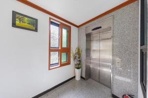 a bathroom with a shower stall and a window at Sokcho White Lighthouse Pension in Sokcho