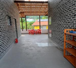 a patio with red tables and chairs in a brick wall at Daon Pension in Inje
