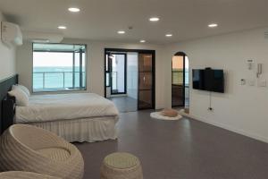 a bedroom with a bed and a flat screen tv at Ulsan Haebeach Pension in Ulsan