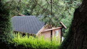a small house with a black roof and some trees at Sobaeksan Log Pension in Danyang