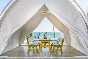 KappawiにあるSinpo Port TITF Caravanの海の前にテーブルと椅子が備わるテントです。 +14枚の写真
