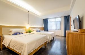 Rúm í herbergi á Zhangjiajie ZhuMan Holiday B&B