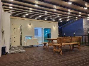 a patio with a wooden bench and a table at A Great View Kids Pool Villa Pension in Miryang