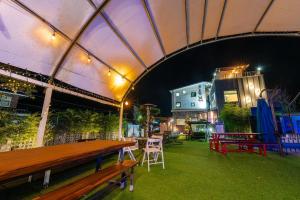 a tent with a table and chairs in a yard at night at Suncheon Slow Pension in Suncheon