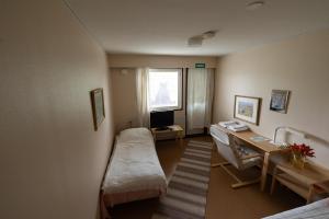 a room with a bed and a desk and a window at Gasthaus.himanka in Himanka