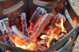 a fire in a grill with flames in it at Inje Naerincheon Glamping in Inje