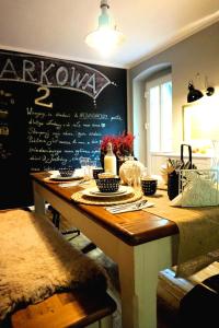 a dining room table with a chalkboard on the wall at Pokoje Gościnne Parkowa 2 in Świeradów-Zdrój