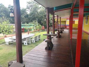 a porch with picnic tables and benches on a playground at Campchamao in Ban Ra-ok