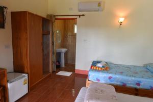a small room with a bed and a bathroom at Campchamao in Ban Ra-ok