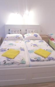 a white bed with two yellow pillows on it at Apartments Messe-Prater in Vienna