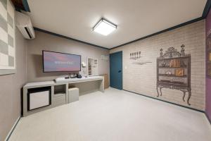 a room with a desk and a tv on a wall at Gangneung Cabin in Gangneung +4 photos