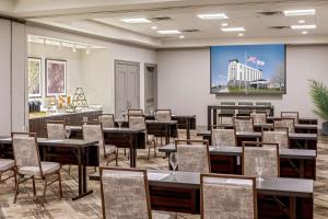 un comedor con mesas y sillas y una pantalla grande en DoubleTree by Hilton Boston Logan Airport Chelsea, en Chelsea
