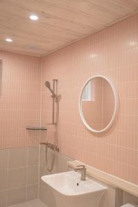 a bathroom with a sink and a mirror and a shower at Gangneung Cheeze Bada in Gangneung