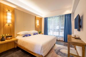 Rúm í herbergi á Zhangjiajie ZhuMan Holiday B&B