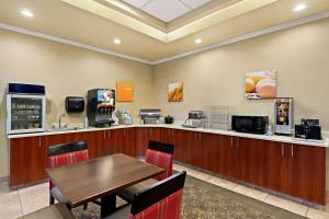 a dining room with a table and a bar at Comfort Inn & Suites Creswell in Creswell