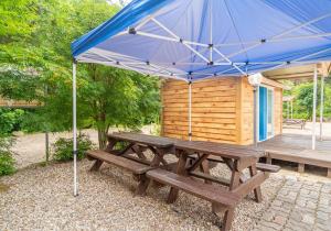 a picnic table with an umbrella in front of a cabin at Baekdam Gyegok Pension in Inje