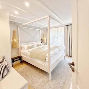 a white bedroom with a white canopy bed at TauberChalet I Privates Boutique-Ferienhaus mit Whirlpool, Sauna, Garten, Naturmagie & ZellBoost in Rothenburg ob der Tauber