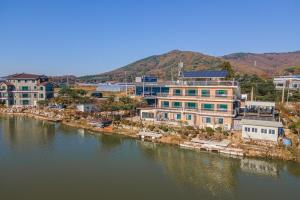 a group of buildings next to a body of water at Ganghwado Pension Riverside in Incheon