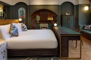圣奥尔本斯The Samuel Ryder Hotel St Albans, Tapestry Collection Hilton的一间卧室配有一张床、一张桌子和一个壁炉 更多37张照片