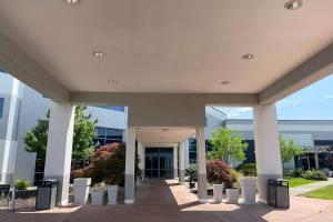 a large building with pillars in front of it at Wyndham Flint MI Grand Blanc Bishop Airport Conference Ct in Flint