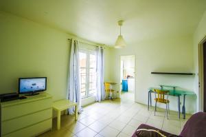 een woonkamer met een tafel en een televisie bij Metz Port Saint Marcel in Metz