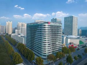 济南济南高新希尔顿花园酒店的高楼林立的城市中的一栋高楼