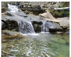 a waterfall in a pool of water in a park at Wolbyeok Town in Seoul