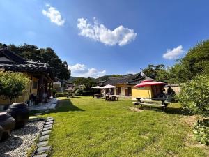 a yard with a building with a picnic table at Sanencheong Namsayedamchon Yedam Hanok Stay in Sancheong