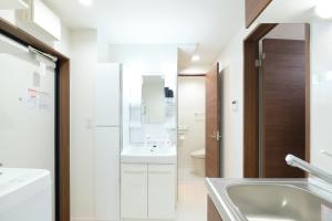une salle de bain blanche avec un lavabo et des toilettes dans l'établissement GRANQUAL Horikiri, à Tokyo
