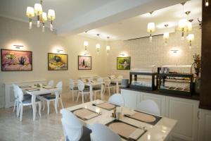 a restaurant with white tables and white chairs at Olivia 9teen Hotel Boutique in Sibiu