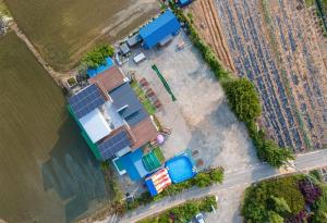 eine Aussicht auf ein Haus mit Sonnenkollektoren neben einem Feld in der Unterkunft Family Couple Pension Harupia in Taean