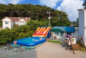 ein Haus mit einem Pool und einem Spielplatz in der Unterkunft Family Couple Pension Harupia in Taean